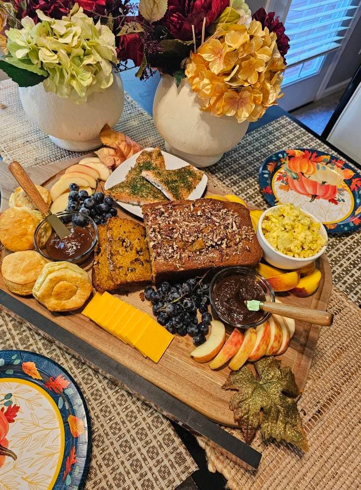 A fall breakfast spread with biscuits, bread, and fruit