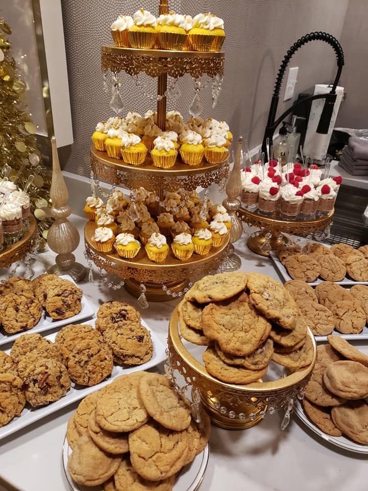 A dessert table of cupcakes and cookies from Something Sweet LLC
