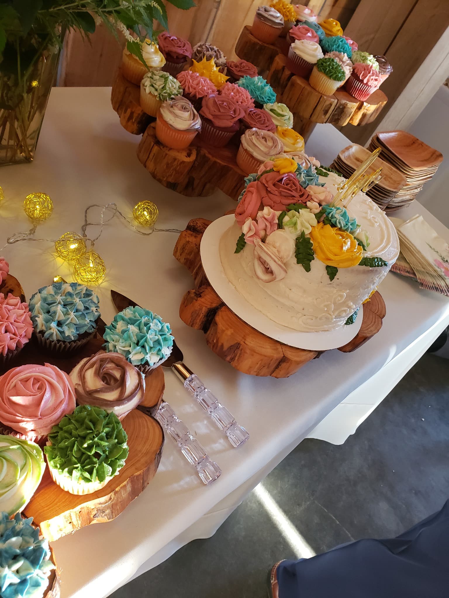 A floral-decorated cake and cupcakes made by Something Sweet LLC